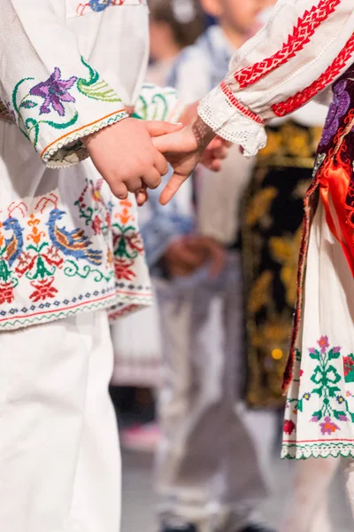 Zbliżenie rąk młodych rumuńskich tancerzy wykonują taniec ludowy w tradycyjnym stroju folklorystycznego. Folklor Rumunii — Zdjęcie stockowe