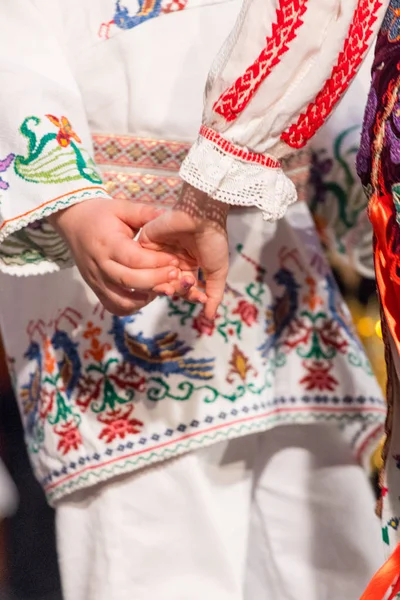 Close-up van handen van jonge Roemeense dansers voeren een volksdans in traditionele folkloristische kostuum. Folklore van Roemenië — Stockfoto