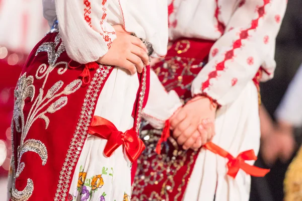 Close-up op handen van jonge Roemeense dansers voeren een volksdans in traditionele folkloristische kostuum. Folklore van Roemenië — Stockfoto