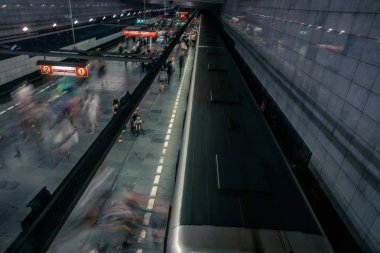 Prag, Çek Cumhuriyeti,23 Temmuz 2019; Metro istasyonundaki insanlar metro trenine biniyor ya da yürüyerek geçiyorlar, hareket için uzun pozlama tekniği. Kent sahnesi, şehir hayatı, toplu taşıma ve trafik konsepti.