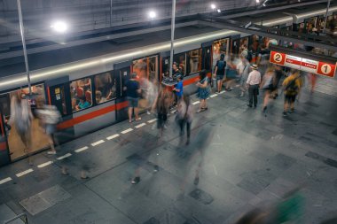 Prag, Çek Cumhuriyeti,23 Temmuz 2019; Metro istasyonundaki insanlar metro trenine biniyor ya da yürüyerek geçiyorlar, hareket için uzun pozlama tekniği. Kent sahnesi, şehir hayatı, toplu taşıma ve trafik konsepti.