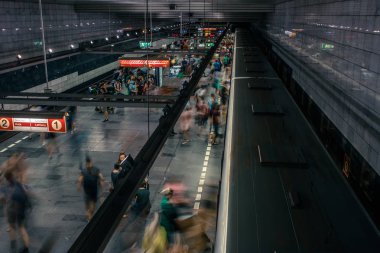 Prag, Çek Cumhuriyeti,23 Temmuz 2019; Metro istasyonundaki insanlar metro trenine biniyor ya da yürüyerek geçiyorlar, hareket için uzun pozlama tekniği. Kent sahnesi, şehir hayatı, toplu taşıma ve trafik konsepti.