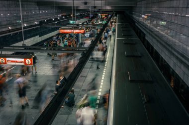 Prag, Çek Cumhuriyeti,23 Temmuz 2019; Metro istasyonundaki insanlar metro trenine biniyor ya da yürüyerek geçiyorlar, hareket için uzun pozlama tekniği. Kent sahnesi, şehir hayatı, toplu taşıma ve trafik konsepti.