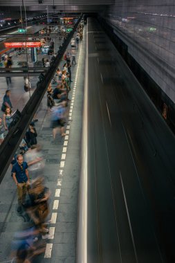 Prag, Çek Cumhuriyeti,23 Temmuz 2019; Metro istasyonundaki insanlar metro trenine biniyor ya da yürüyerek geçiyorlar, hareket için uzun pozlama tekniği. Kent sahnesi, şehir hayatı, toplu taşıma ve trafik konsepti.