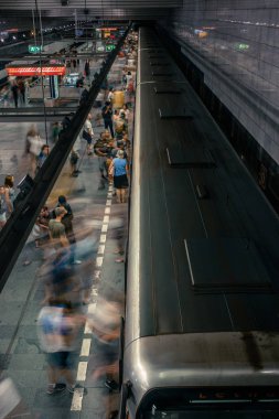 Prag, Çek Cumhuriyeti,23 Temmuz 2019; Metro istasyonundaki insanlar metro trenine biniyor ya da yürüyerek geçiyorlar, hareket için uzun pozlama tekniği. Kent sahnesi, şehir hayatı, toplu taşıma ve trafik konsepti.