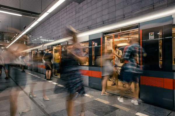 Praha, Česká republika, 23. červenec 2019; Lidé na stanici metra vstupují do vlaku metra, dlouhé expoziční techniky pro pohyb. Městská scéna, městský život, veřejná doprava a dopravní koncepce. — Stock fotografie