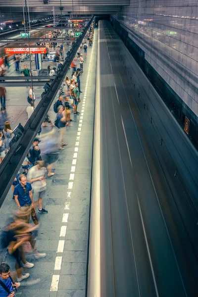 Prag, Çek Cumhuriyeti,23 Temmuz 2019; Metro istasyonundaki insanlar metro trenine biniyor ya da yürüyerek geçiyorlar, hareket için uzun pozlama tekniği. Kent sahnesi, şehir hayatı, toplu taşıma ve trafik konsepti.