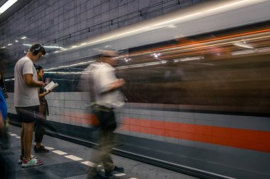 Prag, Çek Cumhuriyeti,23 Temmuz 2019; Metro istasyonundaki insanlar metro trenine biniyor ya da yürüyerek geçiyorlar, hareket için uzun pozlama tekniği. Kent sahnesi, şehir hayatı, toplu taşıma ve trafik konsepti.