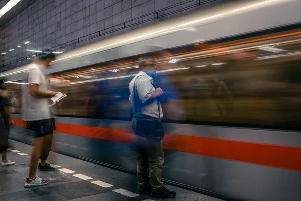 Praga, República Checa, 23 de julho de 2019; Pessoas na estação de metrô que entram no trem de metrô, técnica de longa exposição para o movimento. Cena urbana, vida urbana, transporte público e conceito de trânsito . — Fotografia de Stock