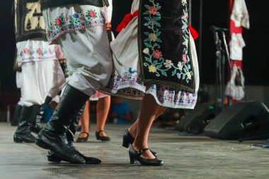 Geleneksel folklorik kostümlü genç Romen kadın ve erkek dansçıların bacaklarını kapatın. Romanya Folkloru