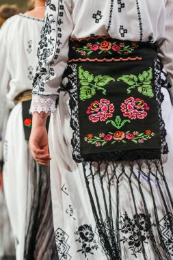 Romanyalı genç bayan dansçı geleneksel folklorik kostümünün detaylarına gir. Romanya Folkloru