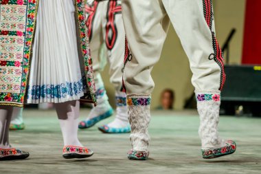 Geleneksel folklorik kostümlü genç Romen dansçının bacaklarındaki yün çorapları kapatın. Romanya Folkloru