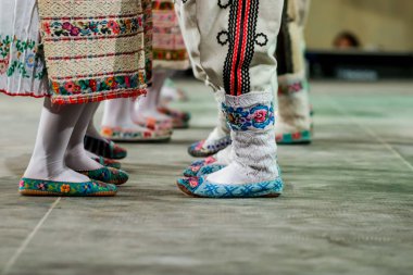 Geleneksel folklorik kostümlü genç Romen kadın ve erkek dansçıların bacaklarındaki yün çorapları kapatın. Romanya Folkloru