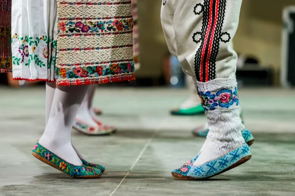 Geleneksel folklorik kostümlü genç Romen kadın ve erkek dansçıların bacaklarındaki yün çorapları kapatın. Romanya Folkloru — Stok fotoğraf