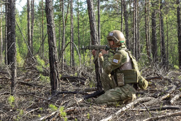 Soldat américain entièrement armé vise un tir dans la forêt d'été, jeu militaire actif airsoft. — Photo