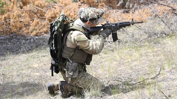 Vollbewaffneter amerikanischer Soldat mit US-Flagge läuft im Sommerwald, aktives militärisches Spiel Airsoft. — Stockfoto