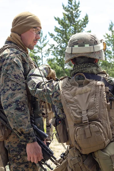 Zwei voll bewaffnete amerikanische Soldaten im Sommerwald auf militärischem Gelände, aktives militärisches Spiel airsoft, vertikales Bild. — Stockfoto