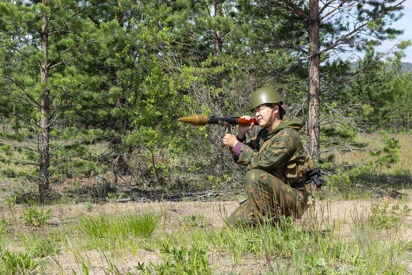 Voll bewaffneter asiatischer Soldat mit Panzerfaust zielt auf einen Schuss im Sommerwald, aktives militärisches Spiel airsoft. — Stockfoto