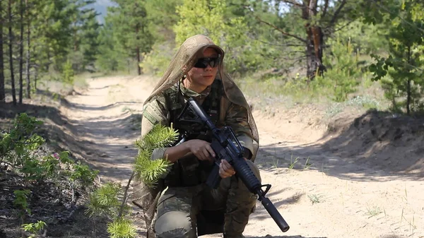 Fully armed american soldier with rifle on the summer forest road, active military game airsoft.