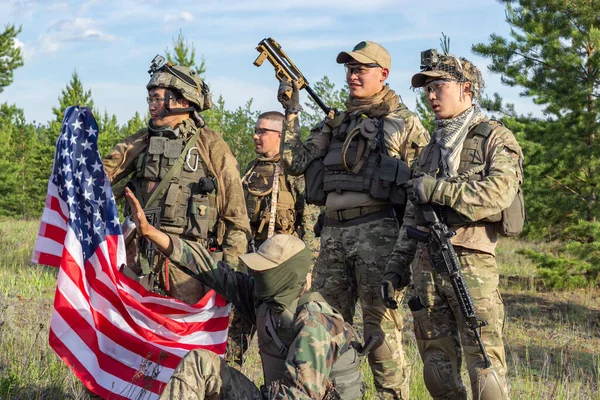 Gruppe voll bewaffneter amerikanischer Soldaten mit US-Flagge nach dem Sieg im Mannschaftsspiel Airsoft auf militärischem Gelände — Stockfoto