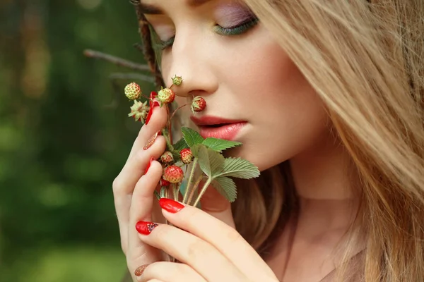 Menina atraente com um pequeno arbusto de morangos em suas mãos — Fotografia de Stock