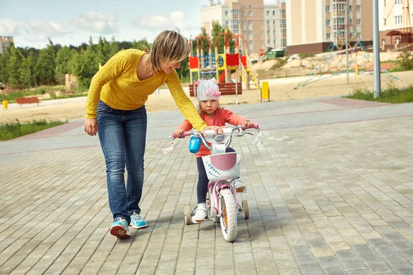 Meisje met moeder fietsen — Stockfoto