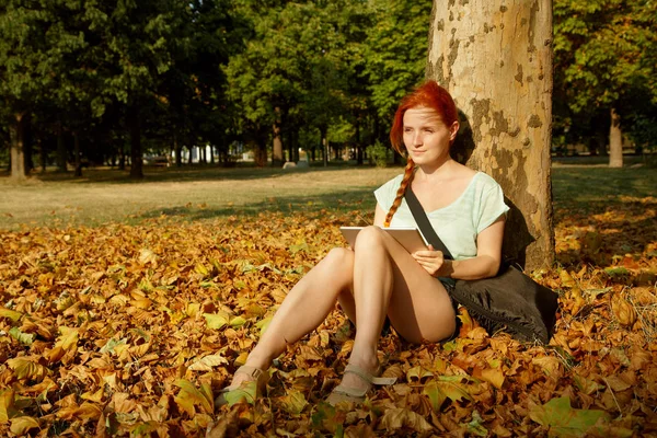 Жінка сидить під деревом в парку — стокове фото