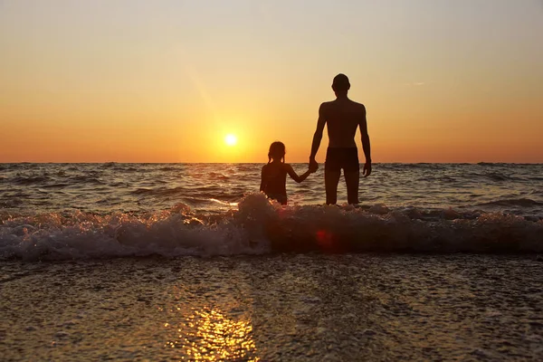 Vader en dochter bij zonsondergang — Stockfoto