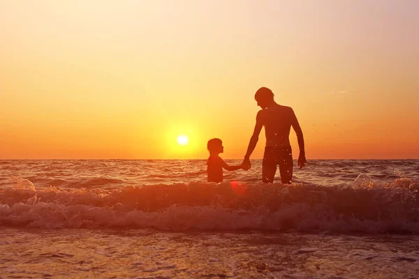 Батько і дочка на заході сонця — стокове фото