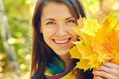 Sonbaharda sarı akçaağaç yapraklı kadın.