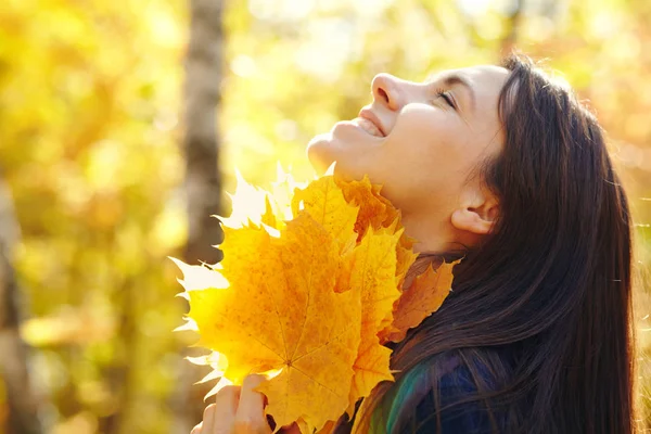 Frau mit gelben Ahornblättern im Herbst — Stockfoto