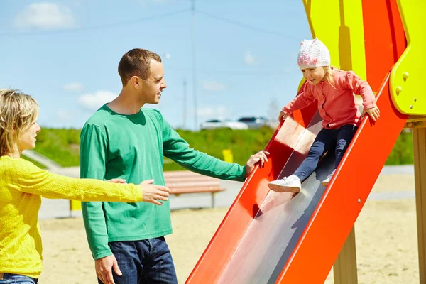 Bambino con i genitori al parco giochi all'aperto — Foto Stock