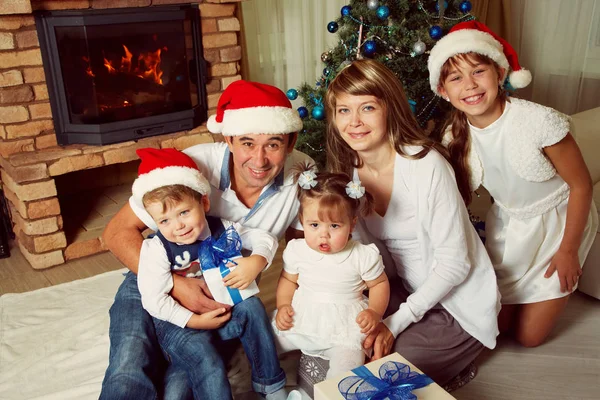 Familie feiert Weihnachten zu Hause auf dem Hintergrund des Weihnachtsbaums — Stockfoto