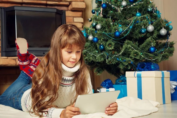Glückliches Teenager-Mädchen mit Tablet-Computer in der Nähe des Weihnachtsbaums — Stockfoto