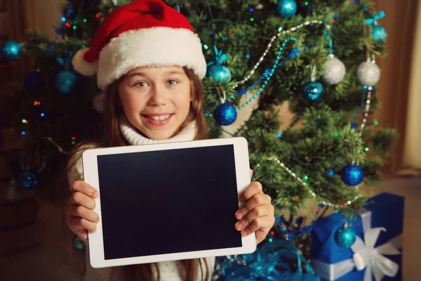 Chica adolescente feliz con la tableta cerca del árbol de Navidad — Foto de Stock