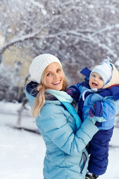Happy mother and baby in winter park. family outdoors — Stock Photo, Image