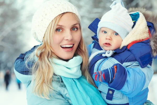 幸せな母と冬の公園で赤ちゃん。屋外の家族 — ストック写真