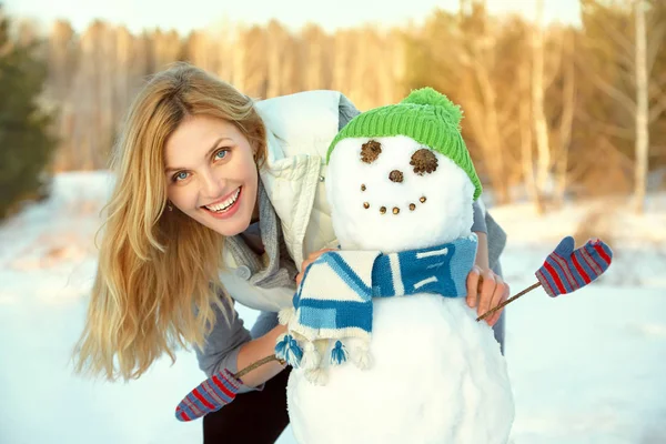 Femme heureuse jouant avec bonhomme de neige en hiver à l'extérieur — Photo