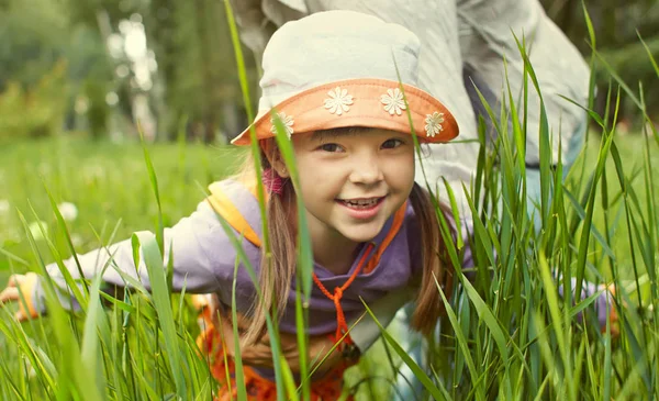 Vrolijk meisje spelen in het gras — Stockfoto