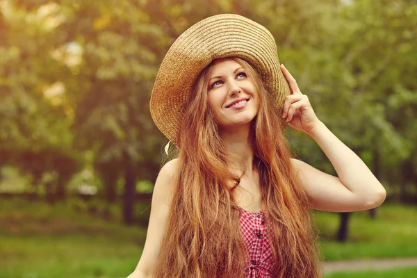 Mujer sonriente en un sombrero en el parque de verano — Foto de Stock