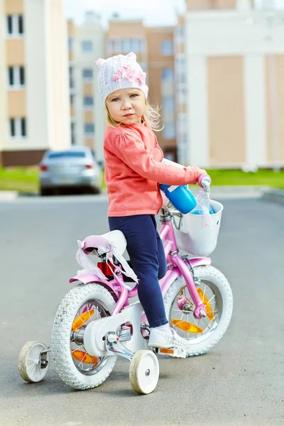 Маленька дівчинка їде на велосипеді. дитина на вулиці — стокове фото
