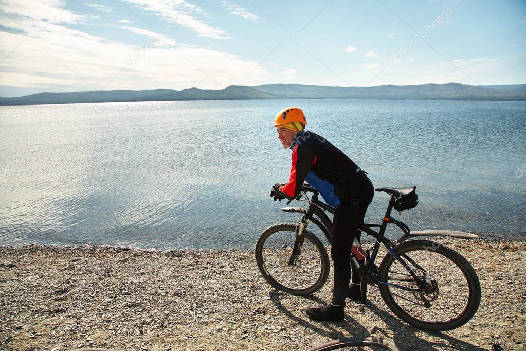 cyclist on the shore of a mountain lake