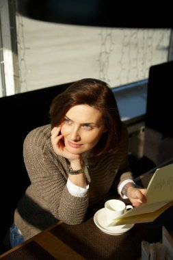 çay ile bir kafede oturan genç ve güzel kadın