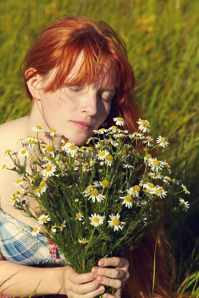 Mulher ruiva com um buquê de flores em um vestido ao ar livre. menina romântica elegante no campo — Fotografia de Stock