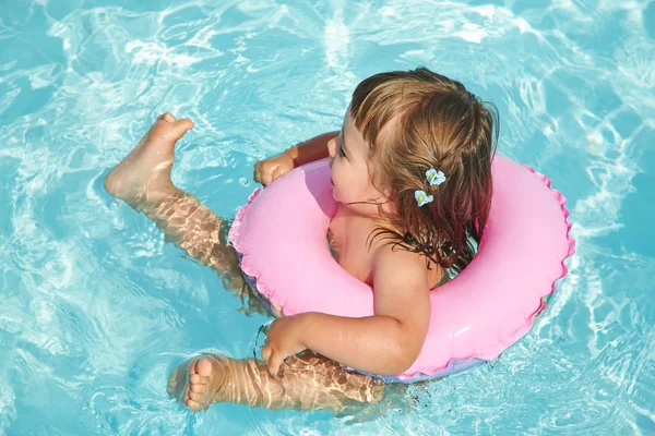 Klein meisje in de cirkel van de opblaasbare zwemmen in zwembad — Stockfoto