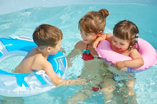 Kinderen in de kring van de opblaasbare zwemmen in zwembad spelen — Stockfoto