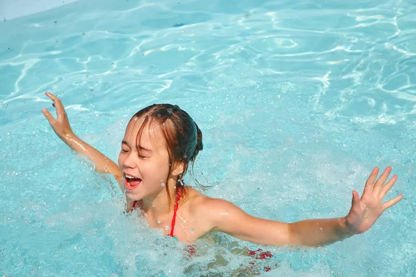 Ontspannen meisje in water in zwembad — Stockfoto