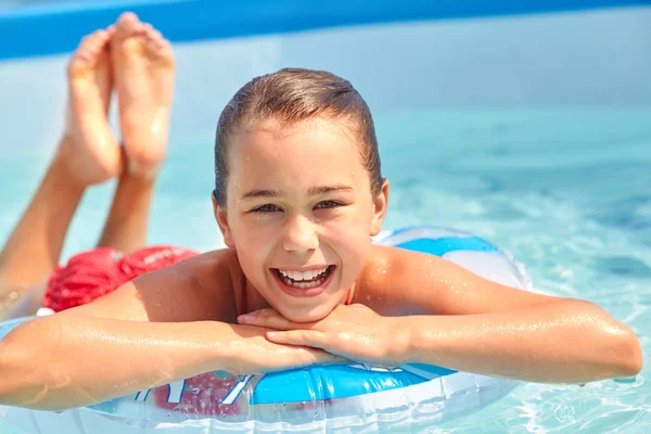 Entspannendes Mädchen im aufblasbaren Schwimmkreis im Schwimmbad — Stockfoto