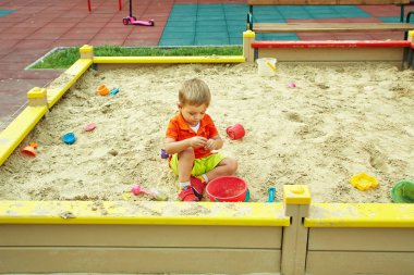 küçük çocuk oyun üzerinde. Çocuk kum havuzunda oynamayı