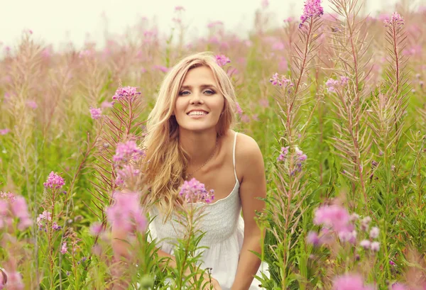 Outdoor Portret van een midden leeftijd blonde vrouw. aantrekkelijke sexy meisje in een veld met bloemen — Stockfoto